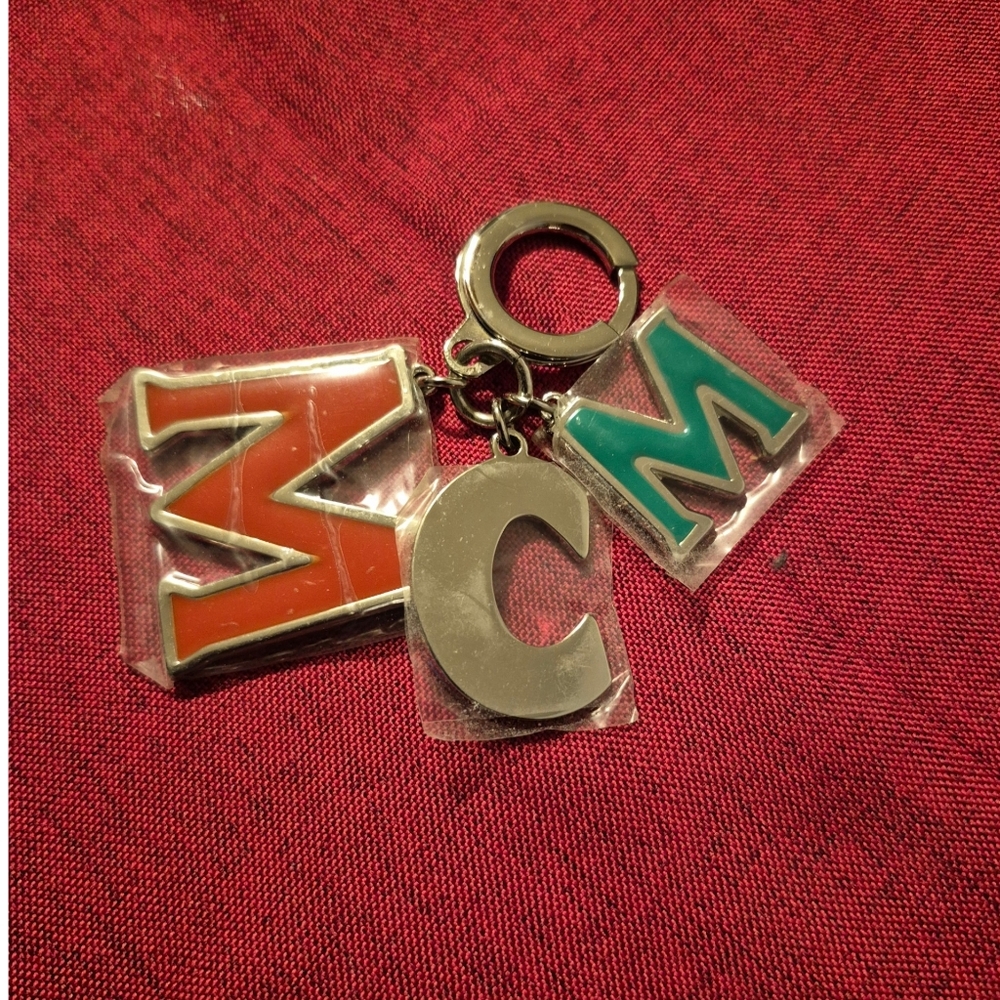 MCM NEW Enameled Logo Keychain/Bag Charm. Stamped MCM (STILL HAS PLASTIC COVER)